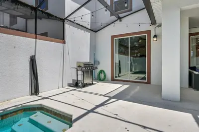 a patio with a swimming pool next to a building at Storey Lake Resort 1085 - Hosted by Top Villas in Kissimmee