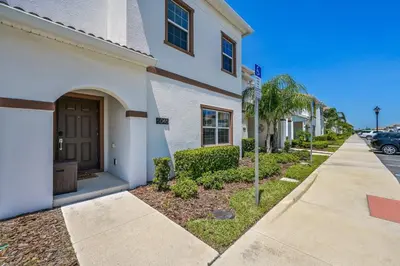 a white building with a door next to a street at Storey Lake Resort 1085 - Hosted by Top Villas in Kissimmee