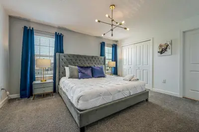 a bedroom with a large bed with blue curtains at Storey Lake Resort 1085 - Hosted by Top Villas in Kissimmee