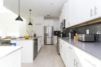 a kitchen with white cabinets and stainless steel appliances at Storey Lake Resort 1086 - Hosted by Top Villas in Kissimmee