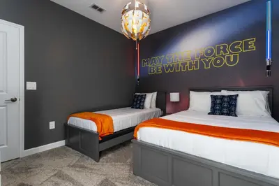 a bedroom with two beds and a chandelier at Storey Lake Resort 1086 - Hosted by Top Villas in Kissimmee