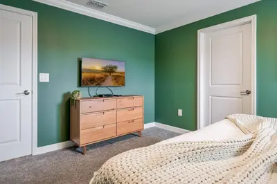 a bedroom with green walls and a bed and a dresser at Storey Lake Resort 1092 - Hosted by Top Villas in Kissimmee