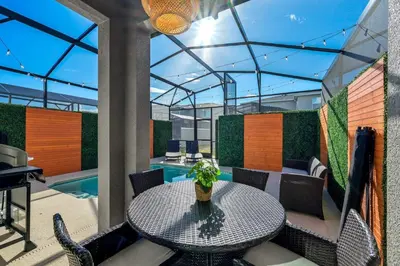 a patio with a table and chairs and a pool at Storey Lake Resort 1092 - Hosted by Top Villas in Kissimmee
