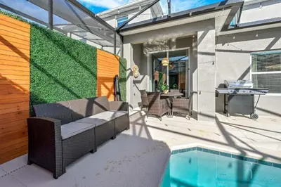 a patio with a pool and a table and a fence at Storey Lake Resort 1092 - Hosted by Top Villas in Kissimmee