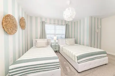 two beds in a room with striped walls at Storey Lake Resort 1113 - Hosted by Top Villas in Kissimmee