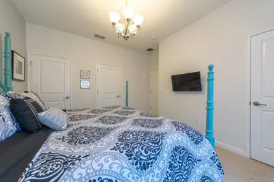 a bedroom with a bed with a blue and white comforter at Last Minute Disney Getaway Townhouse with Private Pool. Book Now 17222 in Kissimmee