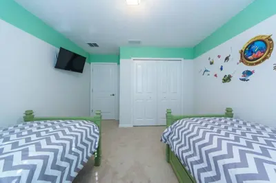 a bedroom with two beds and a television in it at Last Minute Disney Getaway Townhouse with Private Pool. Book Now 17222 in Kissimmee