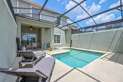 a swimming pool with two lounge chairs and a house at Last Minute Disney Getaway Townhouse with Private Pool. Book Now 17222 in Kissimmee