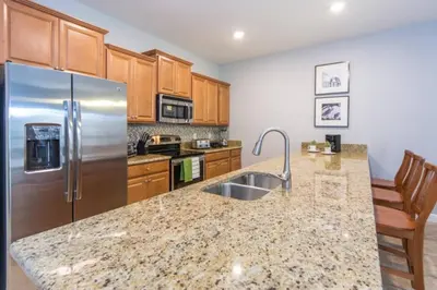 a kitchen with a sink and a stainless steel refrigerator at Last Minute Disney Getaway Townhouse with Private Pool. Book Now 17222 in Kissimmee