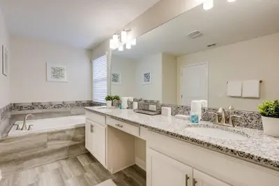 a bathroom with two sinks and a bath tub at Last Minute Disney Private Pool Hot Tub Themed Bedrooms. Book Now 17198 in Kissimmee