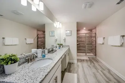 a bathroom with two sinks and two mirrors at Last Minute Disney Private Pool Hot Tub Themed Bedrooms. Book Now 17198 in Kissimmee
