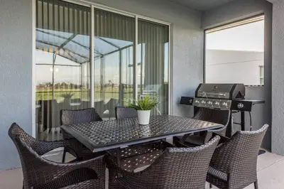 a balcony with a table and chairs and a grill at Last Minute Disney Private Pool Hot Tub Themed Bedrooms. Book Now 17198 in Kissimmee