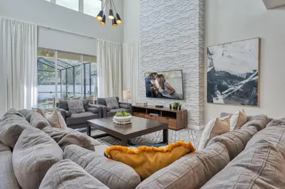a living room with a large couch and a table at Last Minute Disney Private Pool Hot Tub Themed Bedrooms. Book Now 54267 in Kissimmee