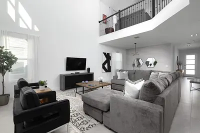 a living room with a gray couch and a tv at Last Minute Disney Private Pool Hot Tub Themed Bedrooms. Book Now 56873 in Kissimmee
