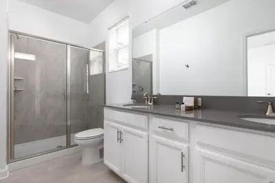 a white bathroom with a toilet and a shower at Last Minute Disney Private Pool Hot Tub Themed Bedrooms. Book Now 56873 in Kissimmee