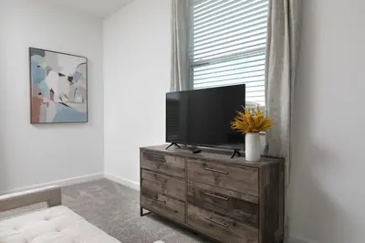 a living room with a television on a wooden dresser at Last Minute Disney Private Pool Hot Tub Themed Bedrooms. Book Now 56873 in Kissimmee