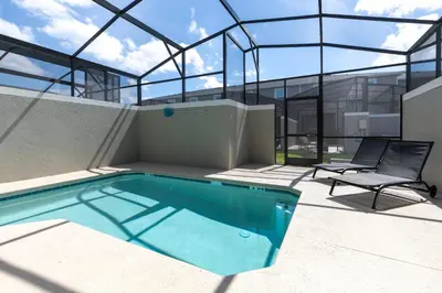 a house with a swimming pool and a chair at Last Minute Disney Getaway Private Pool Themed Bedrooms. Book Now 58079 in Kissimmee