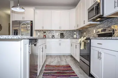 a kitchen with white cabinets and a rug on the floor at Last Minute Disney Getaway Villa with Private Pool Hot Tub. Book Now 22454 in Kissimmee