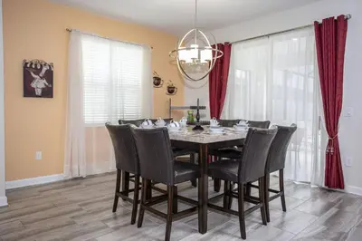 a dining room with a table and chairs at Last Minute Disney Getaway Villa with Private Pool Hot Tub. Book Now 22454 in Kissimmee