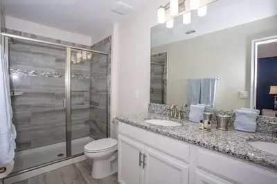a bathroom with a toilet and two sinks and a shower at Last Minute Disney Getaway Villa with Private Pool Hot Tub. Book Now 22454 in Kissimmee