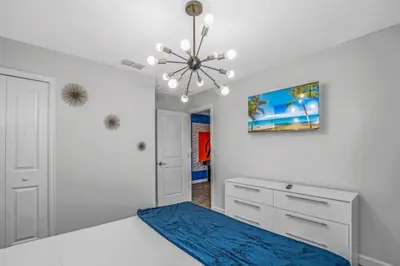 a bedroom with a blue bed and a chandelier at Storey Lake Resort 972 - Hosted by Top Villas in Kissimmee