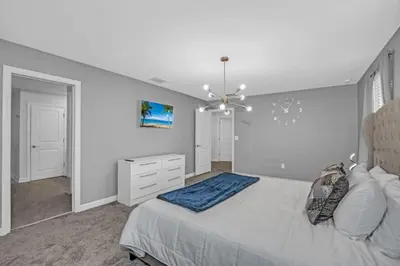 a bedroom with a large bed and a chandelier at Storey Lake Resort 972 - Hosted by Top Villas in Kissimmee