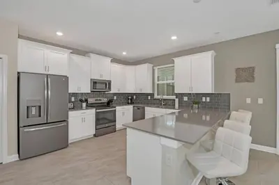 a kitchen with white cabinets and a counter top at Storey Lake Resort 972 - Hosted by Top Villas in Kissimmee