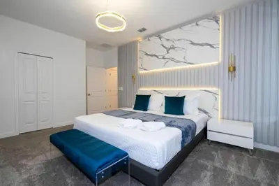 a bedroom with a large bed with a blue bench at Last Minute Disney Private Pool Hot Tub Game Room Themed Bedrooms. Book Now 90505 in Kissimmee