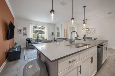 a kitchen with a sink and a living room at Last Minute Disney Getaway Private Pool Themed Bedrooms. Book Now 91409 in Kissimmee