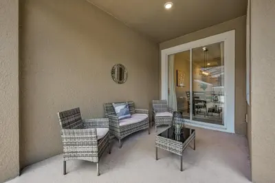 a patio with wicker chairs and a table and a room at Last Minute Disney Getaway Private Pool Themed Bedrooms. Book Now 91409 in Kissimmee