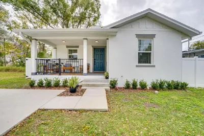 a white house with a blue door at Modern Florida Bungalow 3 Miles to Winter Garden! in Montverde