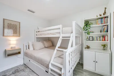 a white bunk bed in a white room with a ladder at Modern Florida Bungalow 3 Miles to Winter Garden! in Montverde