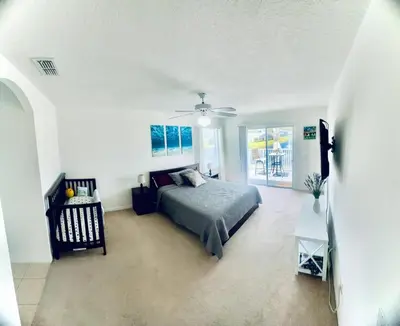 a bedroom with a bed and a ceiling fan at Comfortable House with hot tub close to Disney in Kissimmee