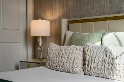 a bedroom with a bed with a lamp and pillows at Wonderful towhouse very close to Disney in Orlando