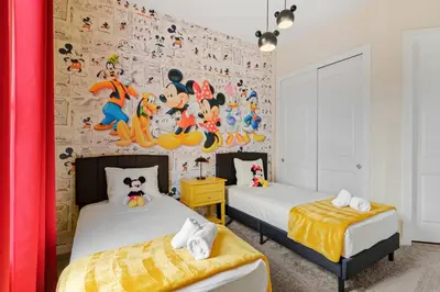 two beds in a room with a wall with cartoon characters at Wonderful towhouse very close to Disney in Orlando