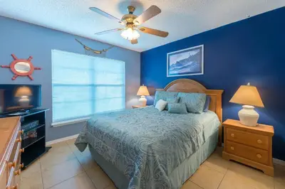 a blue bedroom with a bed and a ceiling fan at 4br/3ba Disney Area Luxury Resort with pool/spa in Orlando