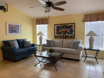 a living room with two couches and a ceiling fan at 4br/3ba Disney Area Luxury Resort with pool/spa in Orlando