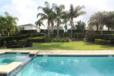 a swimming pool in a yard with palm trees at Family Themed House Close to Disney with Private Pool and Huge Backyard in Orlando