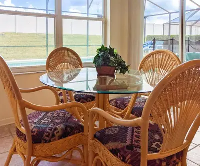 a glass table with chairs and a potted plant on it at 4 Bed 2269 in Kissimmee