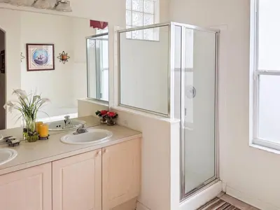 a bathroom with two sinks and a glass shower at 4 Bed 2269 in Kissimmee