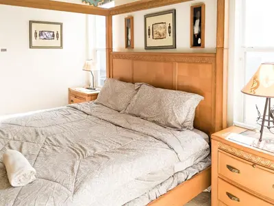 a bedroom with a bed with a wooden headboard at 4 Bed 2269 in Kissimmee