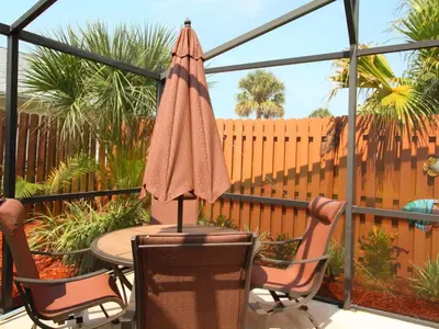 a patio with a table and chairs and an umbrella at 2 Bed 5325 in Kissimmee