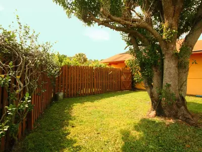 a fence and a tree in a yard at 2 Bed 5325 in Kissimmee