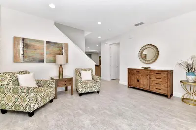 a living room with two chairs and a table at Charming Home With Themed Rooms, Game Room And Waterpark & Resort Access Near Disney At Encore Resorts Reunion - 300Pn in Kissimmee