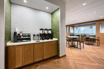 a kitchen with a counter and a table with chairs at Fairfield by Marriott Inn & Suites Orlando at Millenia in Orlando
