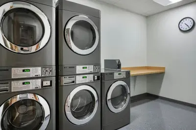 four washing machines in a laundry room with a clock at Fairfield by Marriott Inn & Suites Orlando at Millenia in Orlando