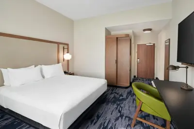 a hotel room with a bed and a desk at Fairfield by Marriott Inn & Suites Orlando at Millenia in Orlando