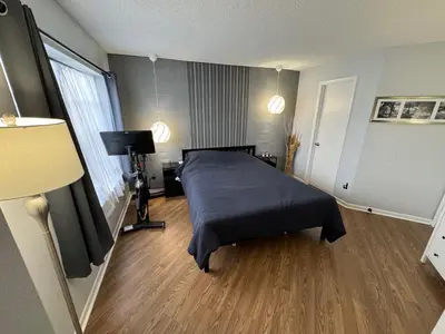 a bedroom with a bed with a blue blanket at Disney and Airport 15 minutes from Luxury Condo in Orlando