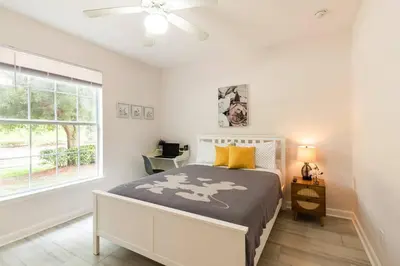 a bedroom with a bed and a window at Newly Renovated First Floor 3Bed & 2 Bath, OUTDOOR POOL, 10-min to Disneyworld & Animal Kingdom! in Kissimmee