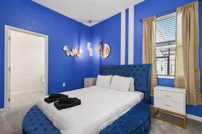 a blue bedroom with a bed and a blue wall at Family-Friendly Luxury Home Near Disney & More in Kissimmee